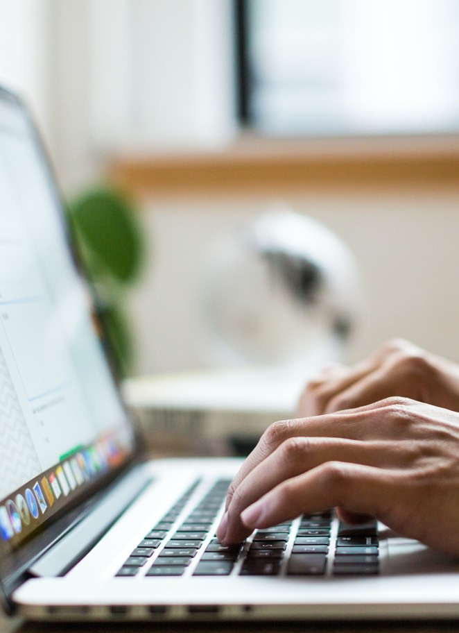 Close up image of hands typing on a laptop