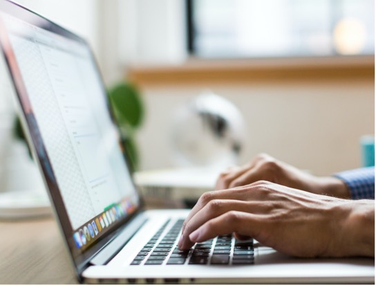 Close up image of hands typing on a laptop