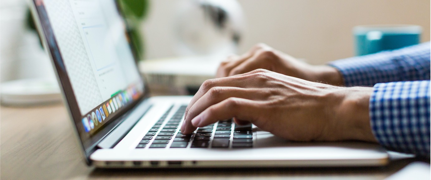 Close up image of hands typing on a laptop