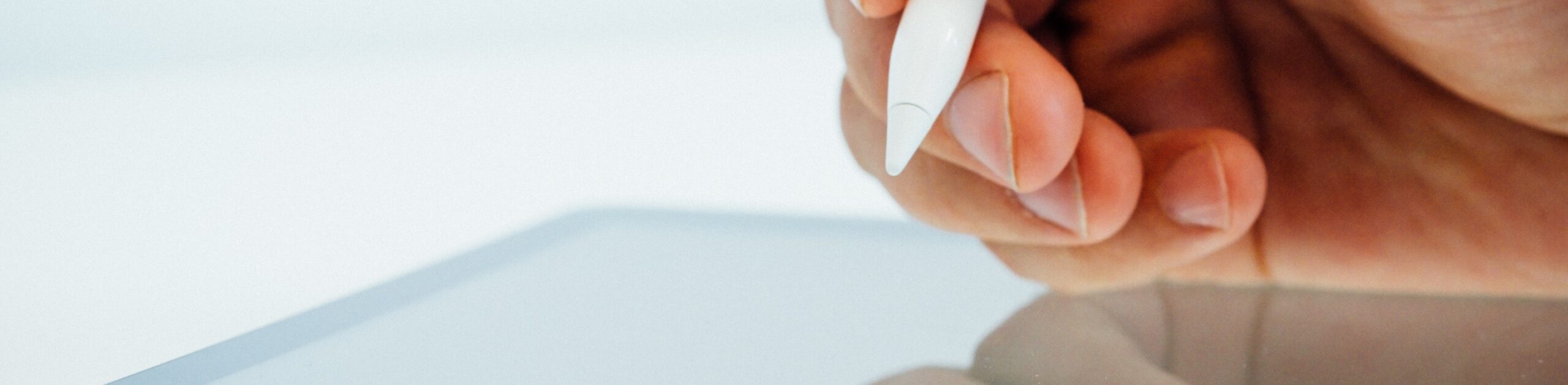 Close up of hand using a smart pen on a tablet.