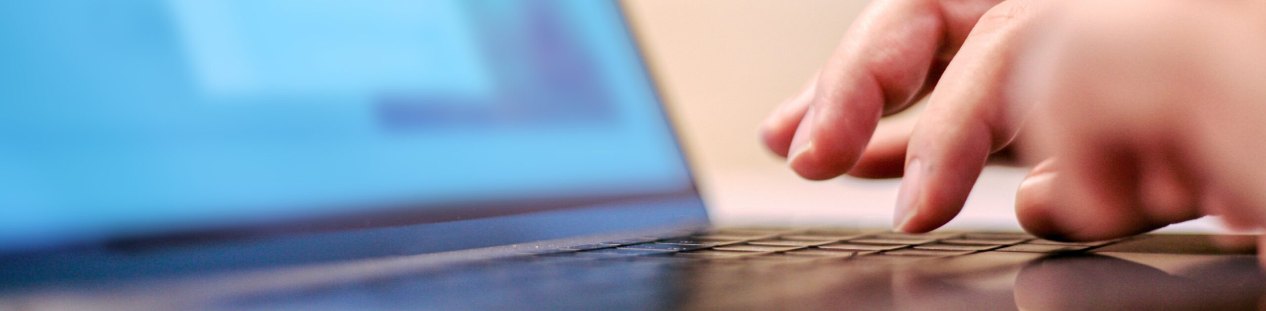 Close up image of a hand typing on a laptop