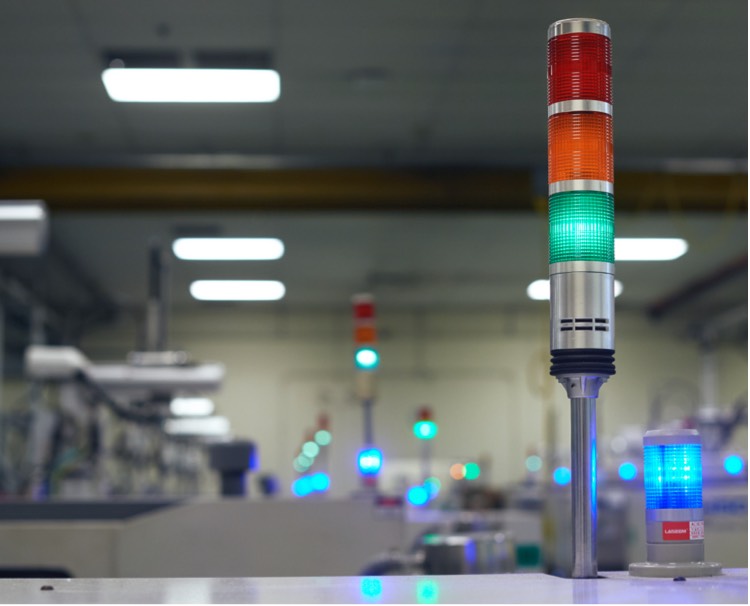 Close up image of a colored indicator light with factory in the background